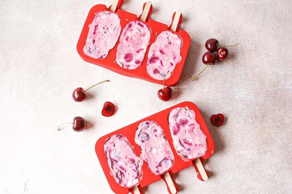 cherry cheesecake popsicles in a red popsicle mold