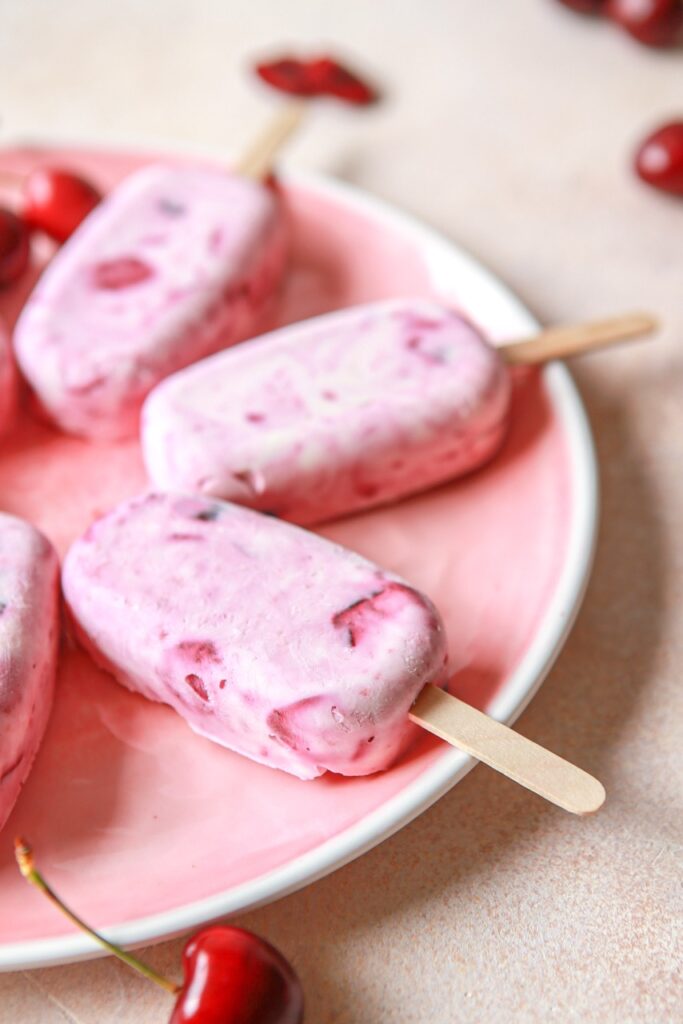Cherry cheesecake popsicles on a pink plate