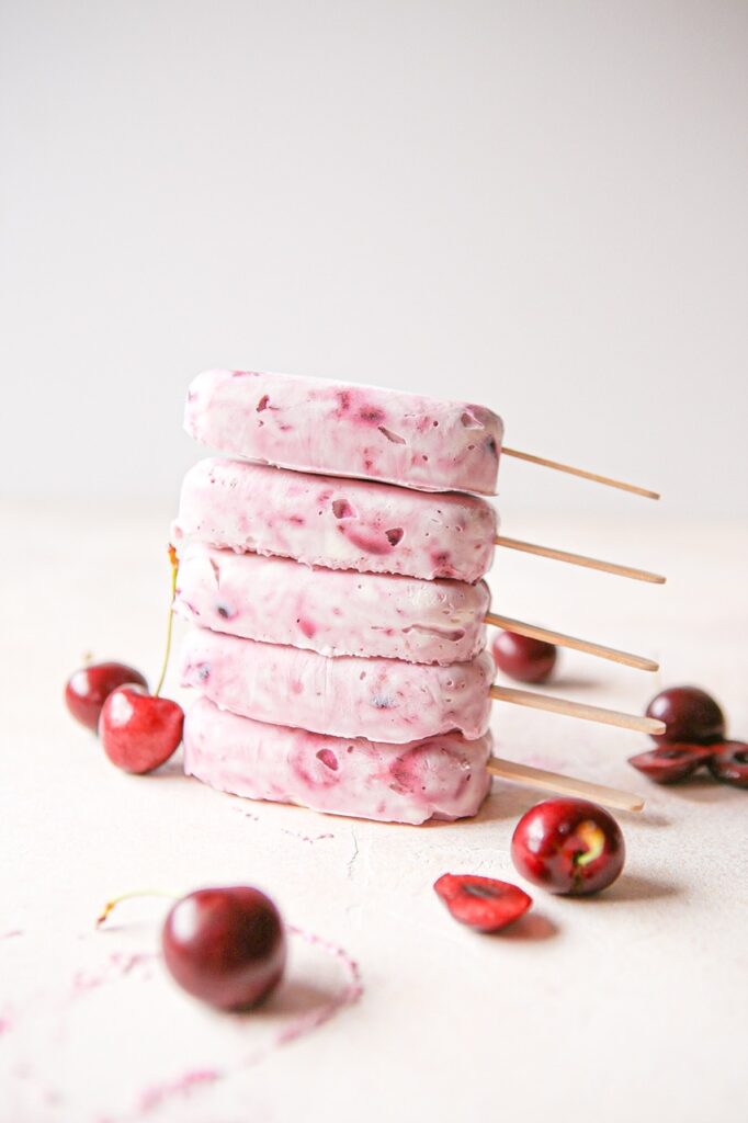 Cherry cheesecake popsicles stacked on top of one another
