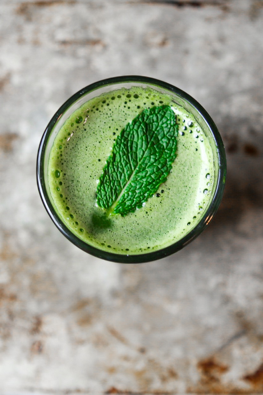 top down view of a gorgeous vibrant green juice with a fresh mint leaf on top