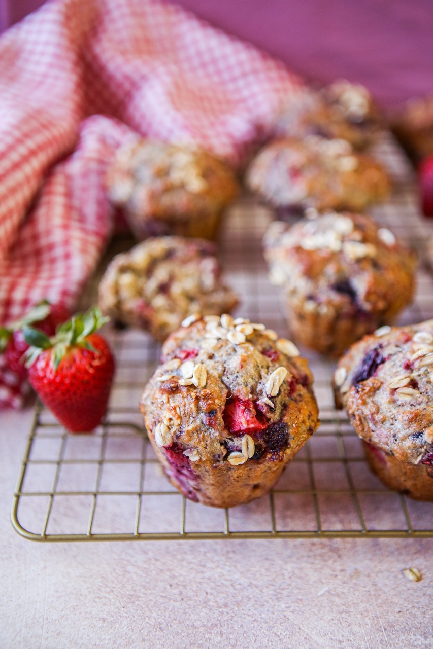 Triple berry muffins on a gold cooling rack