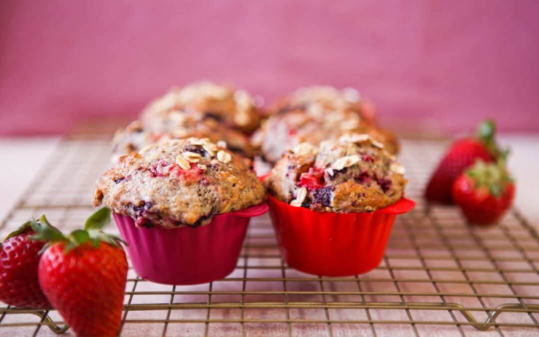 freshly baked berry oat muffins with fresh strawberries
