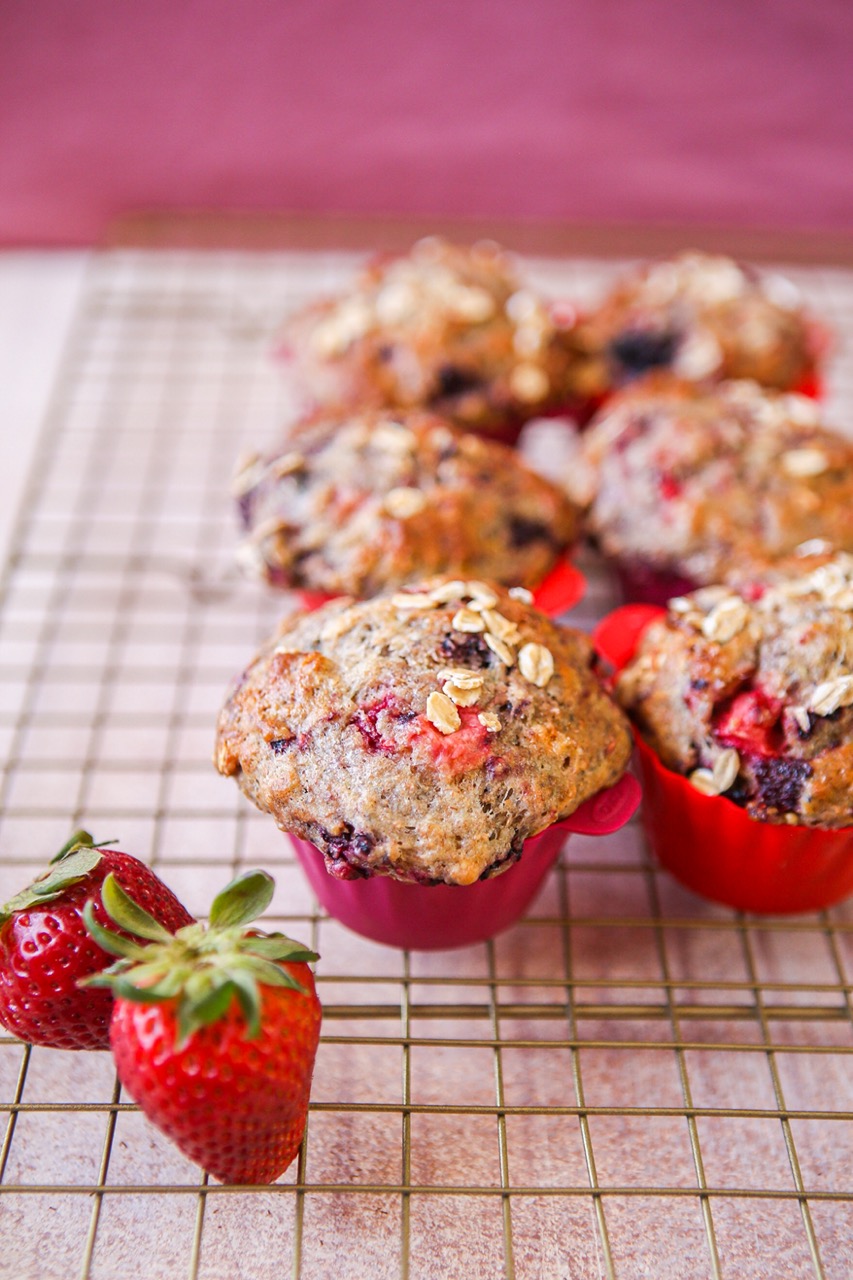 Triple berry oat muffins in liners on a cooling rack