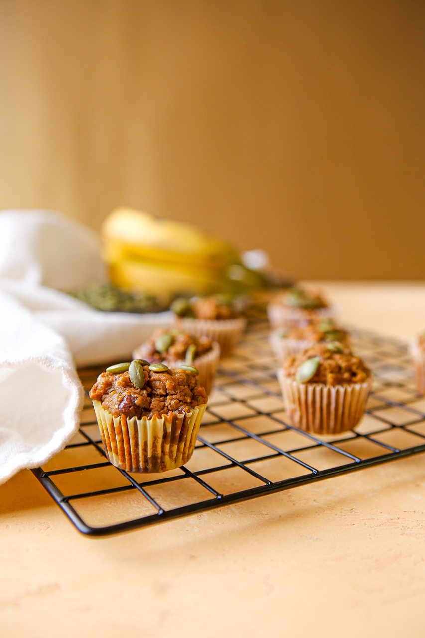 Beautiful mini muffins on a cooling rack with bananas