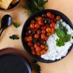 A dish of whipped feta with roasted tomatoes and sourdough crostini