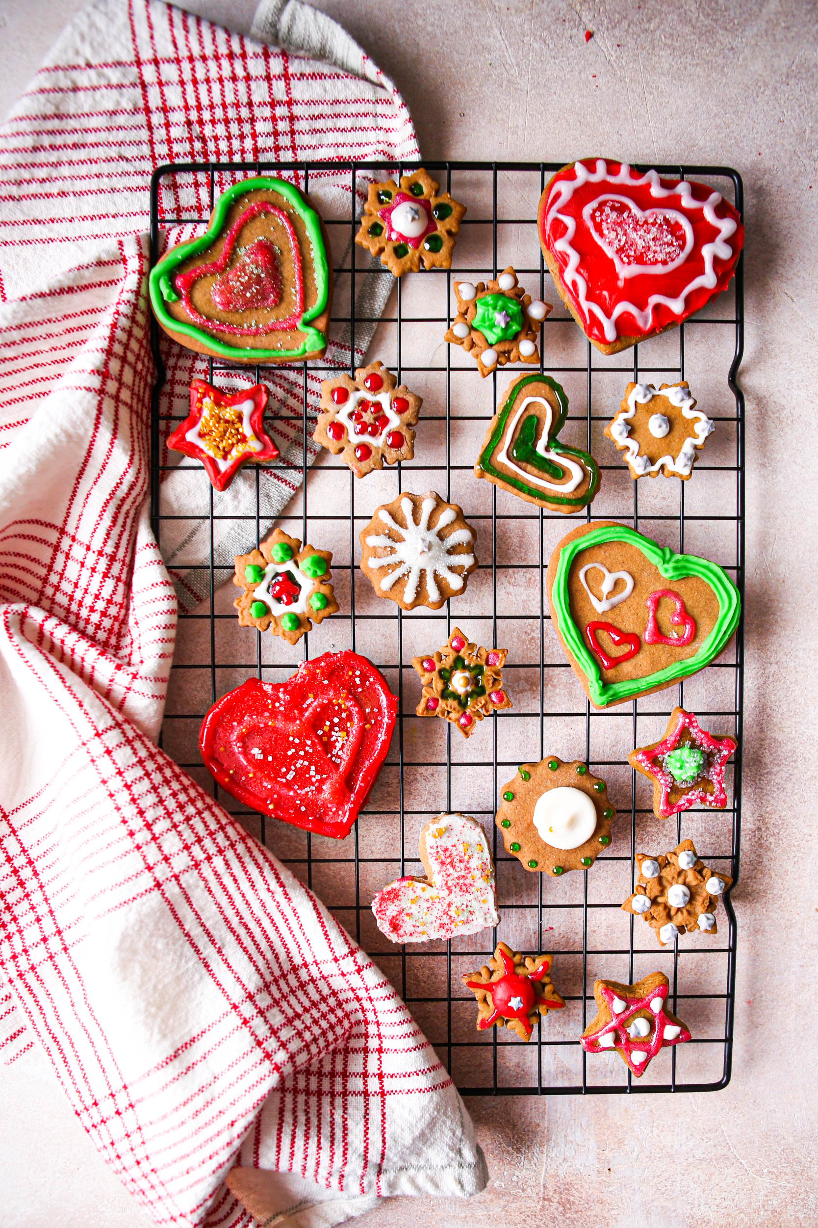 Gingerbread cookies decorated with colored icing on a cooling rack. 