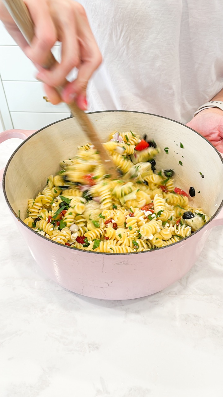 Stirring the pasta salad together.